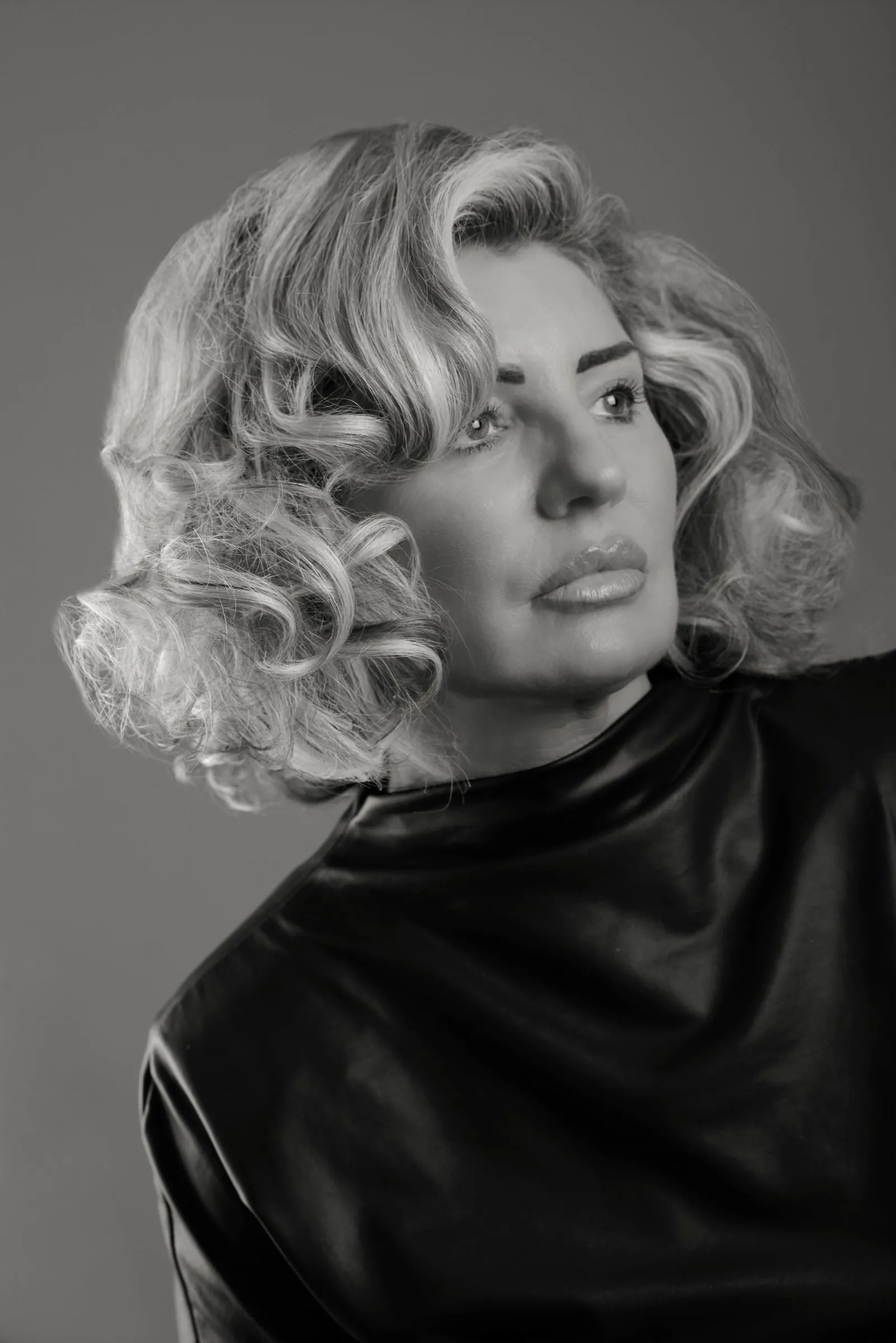 Voluminous curled bob in soft, vintage-style waves with bright highlights