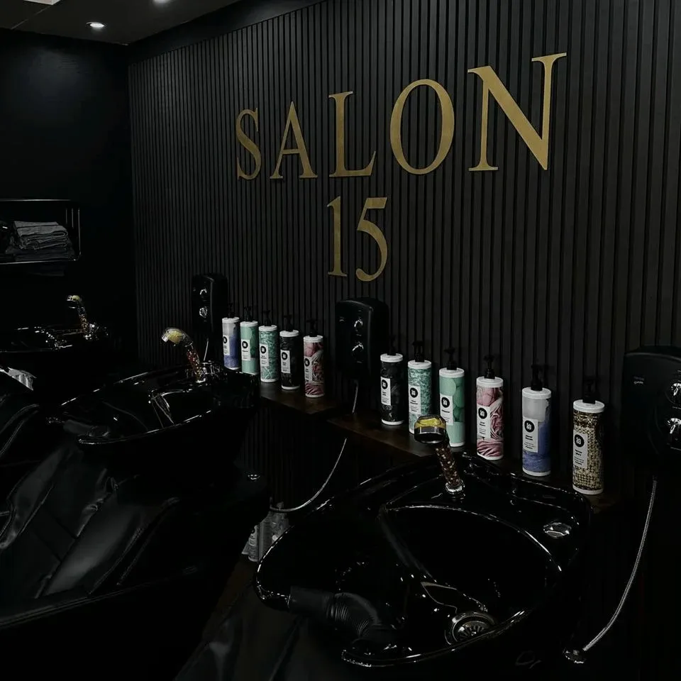 The gold Salon 15 lettering above the black wash basins at the Normanton salon